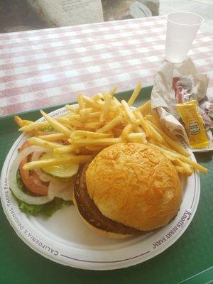 Veggie burger on a gluten free bun with fries.