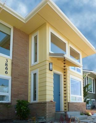 New entry and stair tower with windows opens views and light to both floors of house.