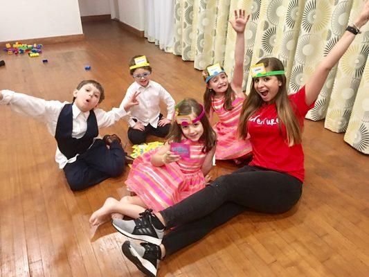 Yillan interacting with the children playing Hedbanz