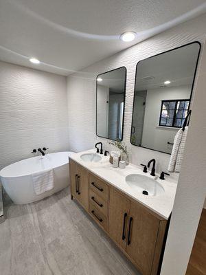 Stylish renovation with updated full wall tile, oak vanity, and a touch of black hardware to make the details pop.