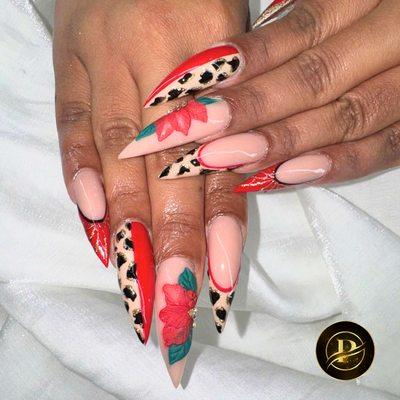 Red stiletto nails with delicate floral accents
The bold red shade combined with soft leaf details creates a stunning and elegant look. P