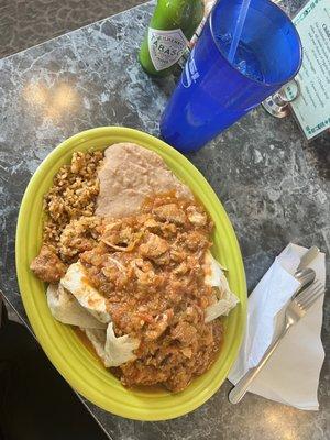Shredded chicken burrito with rice and beans as sides.