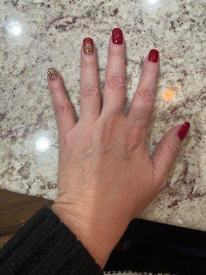 Red dip nails with gold glitter on one nail and ombré on another.