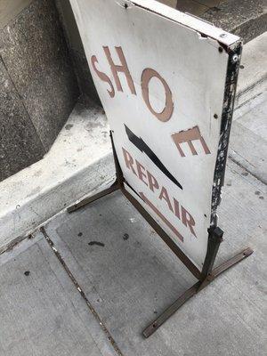 The shoe repair sign that sits on the street is easy to spot