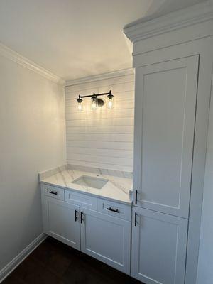 Quakertown PA powder room update. Linen closet built up to ceiling. The back wall is finished off with ship lap and three light sconce.