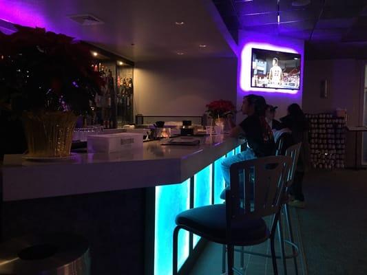 Dimly lit atmosphere with a colorful modern bar top.