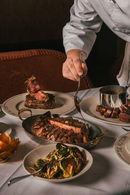 The server helping serve the alston steak sauce