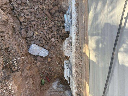 Helical pier with True lift bracketing system attached to the footer to lift and stabilize the home.