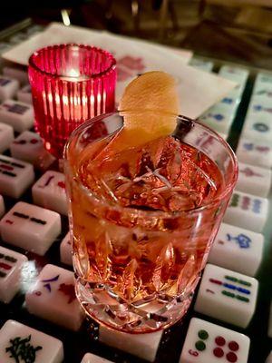 Cocchigroni. Botanist Gin, Cocchi Americano, Velvet Falernum, Campari, orange twist. On a rock.