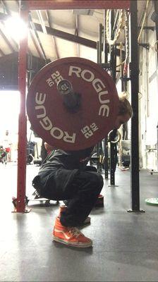 Trainer Daniel showing clients the proper squatting technique.