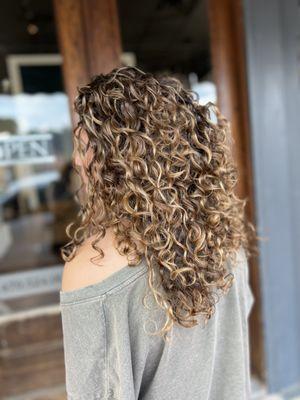 Balayage, curl cut, and curly style out.