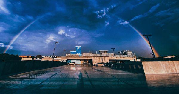 A rainbow as you look out over the upper level of the parking garage towards the rooftop terrace.