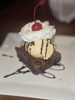 Warm brownie with ice cream, whipped cream & a cherry