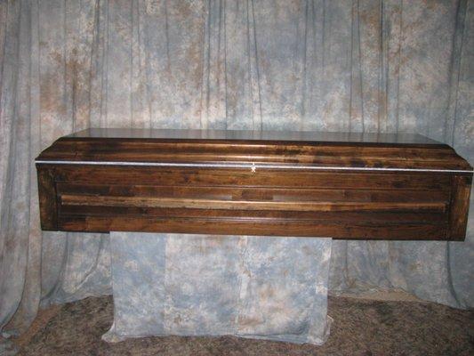 Premier pine casket with a one pc lid solid wood handles with a dark brown stain and a light blue liner 799.00 plus shipping and handling
