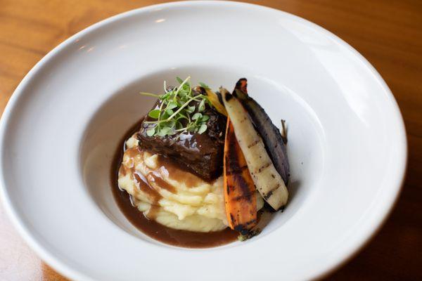 Beef short ribs, braised in a red wine demi sauce, served with whipped potatoes and chef's daily vegetables