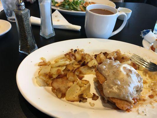 (Half of) my Eggs Benedict with Sausage gravy over poached eggs, fried chicken, country biscuit, and life-changing) homemade Harissa sauce-