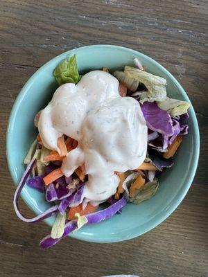 Fresh green salad topped off with ranch dressing.