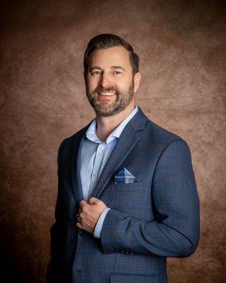Omaha headshot photography of a business headshot in front of a brown backdrop