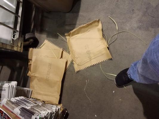 Bundle wrappers and ties strewn all over the floor by the Managers folder. A slip and fall waiting to happen.