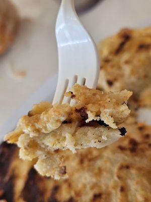 Close-up of a fork holding a piece of a Pupusa.