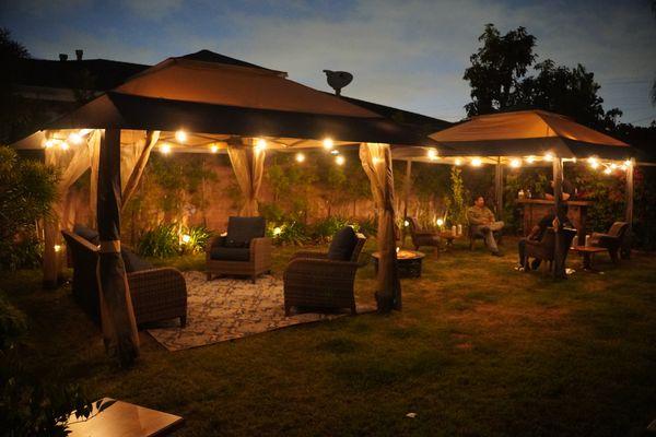 Full lounge set up including tents, furniture, lights, fireplace and service bar.