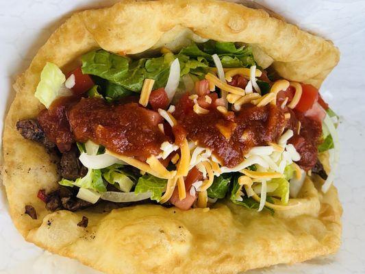 Savor our delicious frybread taco with juicy chicken/steak, topped with fresh lettuce, tomato, & onion all wrapped in a warm fluffy frybread