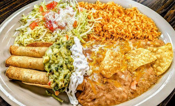 Three taquitos with real guacamole, rice and beans. Shredded lettuce with tomatoes and queso Blanco