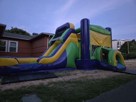 Radical green extreme bounce house and slide combo rental at apartment complex in South Seattle.