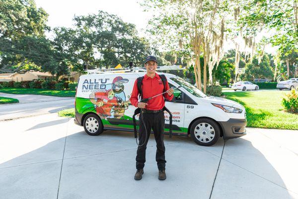 Technician standing in front of his pest control van in a driveway.