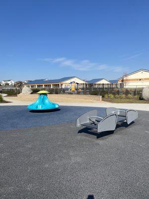 Seesaw, merry-go-round, sandpit in the background