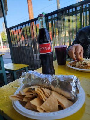 Breakfast burrito with chips and a Mexican coke.