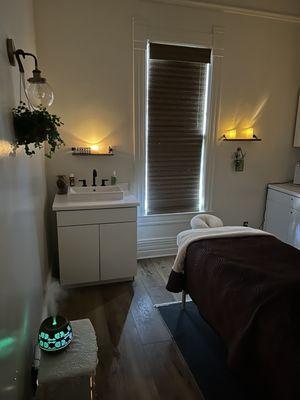 Lovely massage room with candles everywhere and fireplace and diffuser