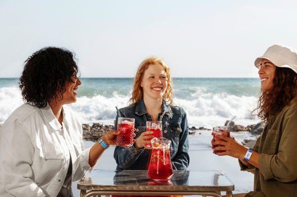 a group on the beach bar drinking punch happy with cashless resort wristbands