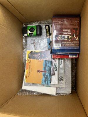 This box is a Ps5 (500$) stacked ON TOP of vinyl records (at least 200$ worth) in a half empty box with scissors, a camera and DVDs..
