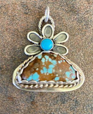 Sterling silver pendant with large Kingman turquoise stone. Flower motif with small Sleeping Beauty Turquoise.