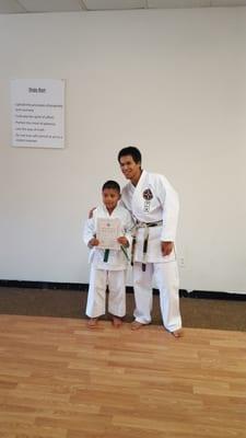 Mr. Emerson and Sensei Juan posing with his Green Belt certificate.