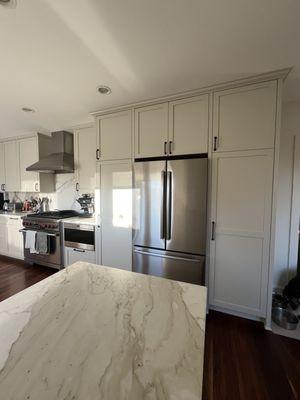 new pantry cabinet to right of refrigerator that exactly matches existing pantry and other cabinets