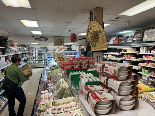 Freezers along the back and coolers with fresh packaged foods.