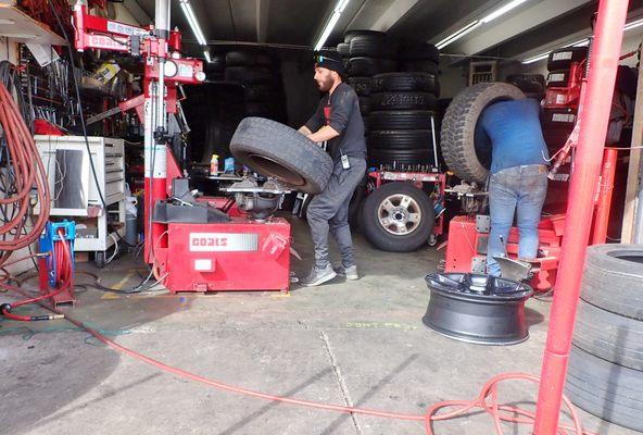 Left - busting my old tires off the rims; right - repairing and patching a big tire flat.