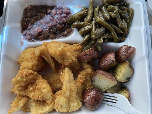 To-go plate of fried fish, potatoes, field peas, and green beans
