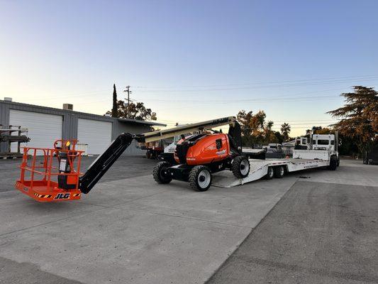 New JLG boom lift being loaded on a truck that is sold.