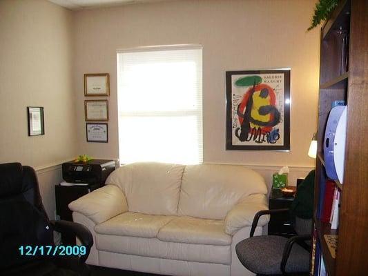 There is a comfortable love seat and an office chair for client seating.