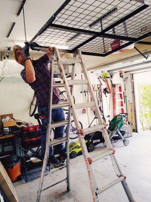 Billy expertly installing an over head storage in one customer's garage. We can do any & all types of installs for home or business.