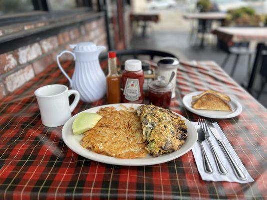House Omelette, hash browns, sourdough toast, house coffee in a white carafe, and homemade strawberry jam.