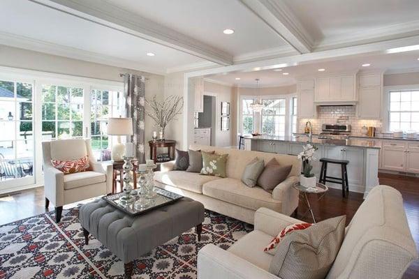 Open Living space, well defined by arched openings and ceiling trim receive natural light from large windows and patio doors.