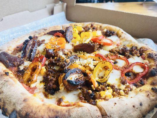 Red pizza with slice dates, bell peppers and meat