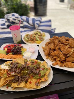 Chicken strips & a mound of fries. Carne asada nachos. Fruit. Shrimp ceviche tostadas