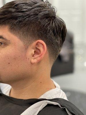 Mid fade with pointed sideburns