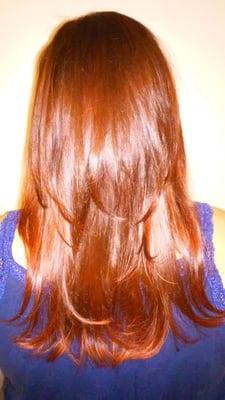 Vibrant red with long layered hair cut.