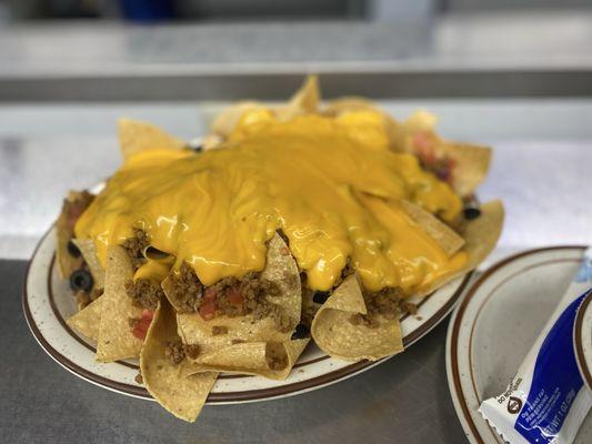 Nacho Grande: Crispy Chips loaded with meat, tomatoes, black olives, onions, and jalapeños.